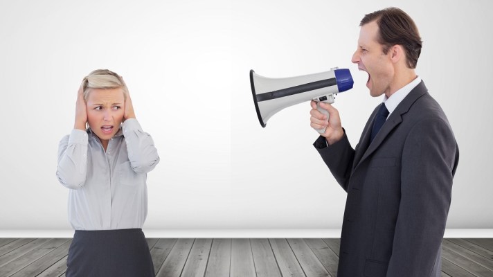 Businessman shouting with a megaphone at his colleague