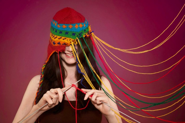 Lady knitting on her own hat